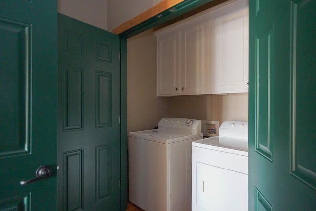 clothes washing area with cabinets and washer and dryer