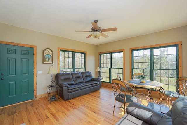 living room featuring ceiling fan, light wood-type flooring, and a wealth of natural light