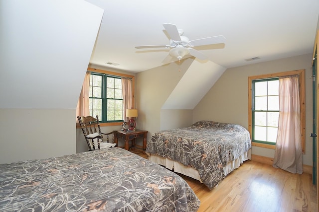 bedroom with ceiling fan, lofted ceiling, and light hardwood / wood-style floors