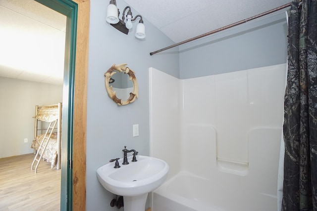 bathroom with shower / tub combo, sink, and hardwood / wood-style flooring