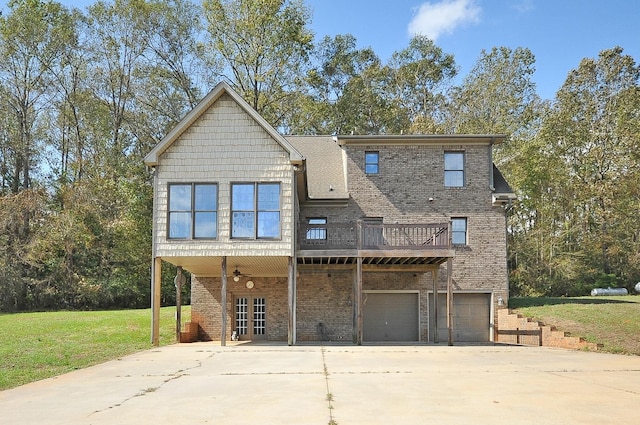 back of property with a lawn, a deck, and a garage