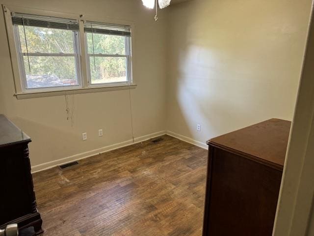 empty room with ceiling fan and dark wood-type flooring