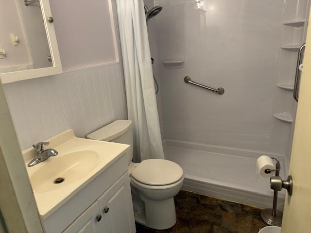 bathroom with walk in shower, vanity, and toilet