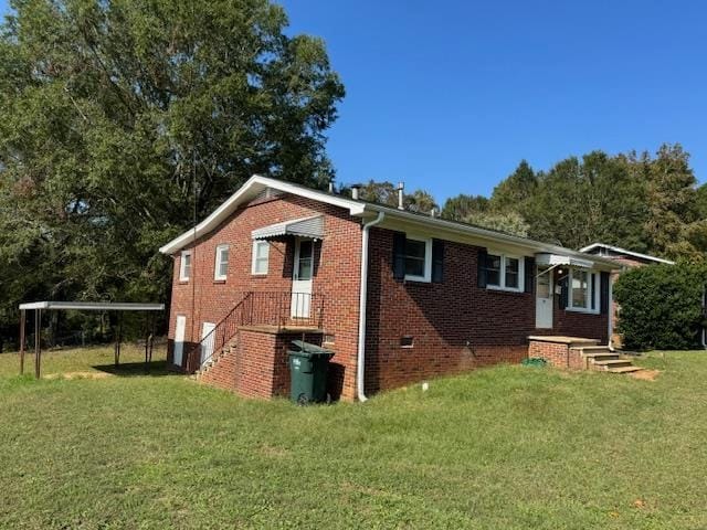 back of property with a carport and a yard