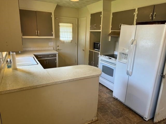 kitchen featuring white appliances, kitchen peninsula, and sink