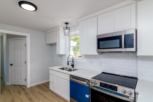 kitchen featuring stainless steel appliances, light wood-type flooring, sink, and white cabinetry