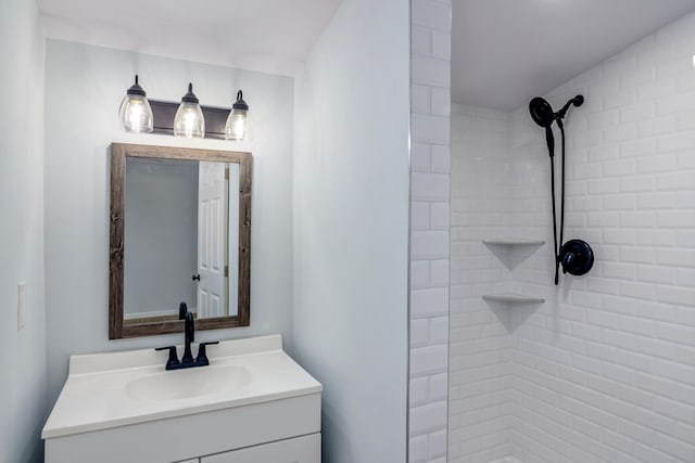 bathroom featuring a tile shower and vanity