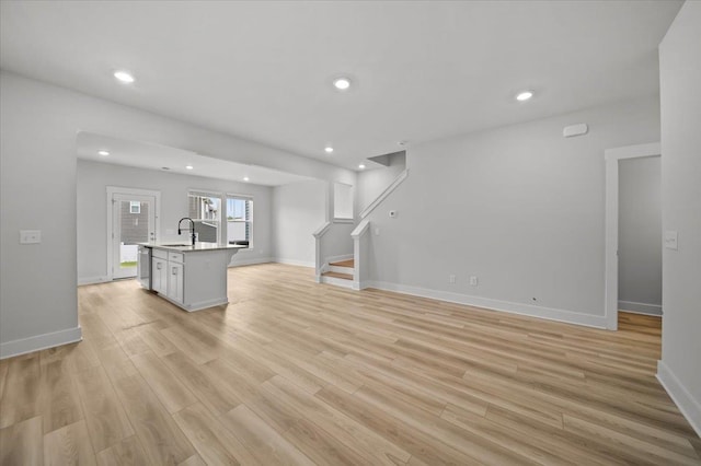 unfurnished living room featuring light wood-type flooring and sink