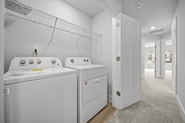 laundry room with light colored carpet and independent washer and dryer