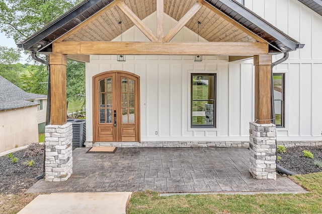 view of exterior entry with central AC and french doors