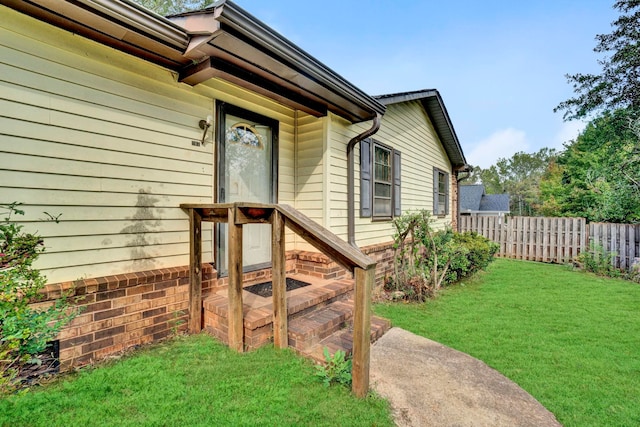 view of exterior entry with a lawn