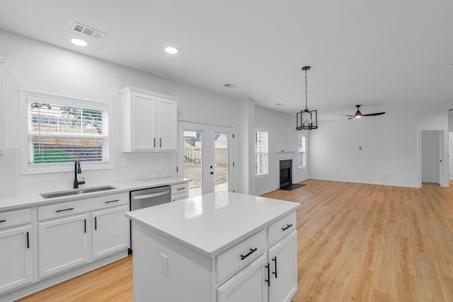 kitchen featuring white cabinets, plenty of natural light, sink, and a center island