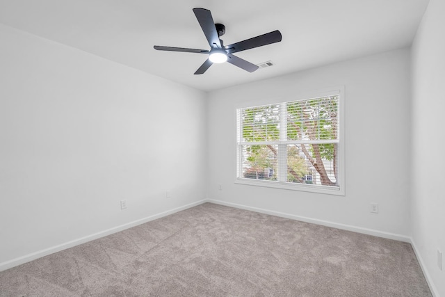 carpeted spare room with ceiling fan