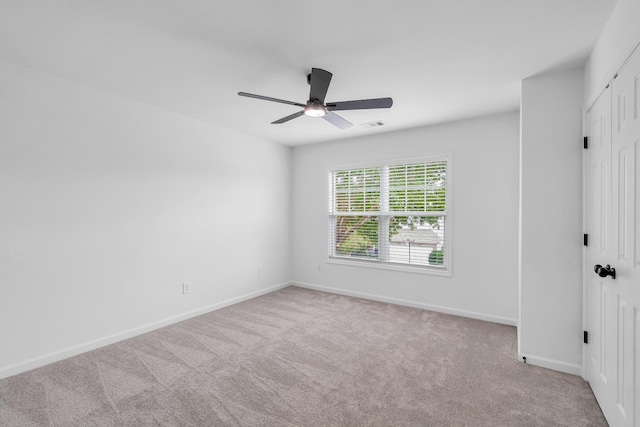 carpeted spare room with ceiling fan