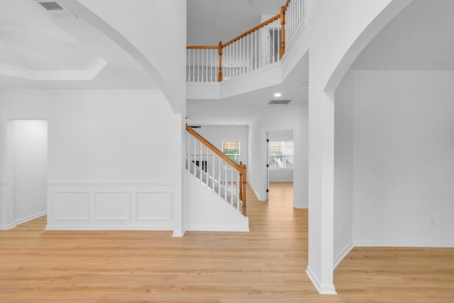 staircase with wood-type flooring and a high ceiling