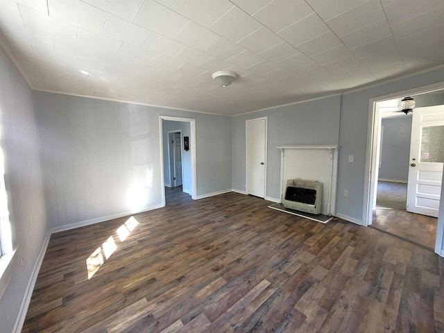 unfurnished living room featuring heating unit, crown molding, and dark hardwood / wood-style flooring