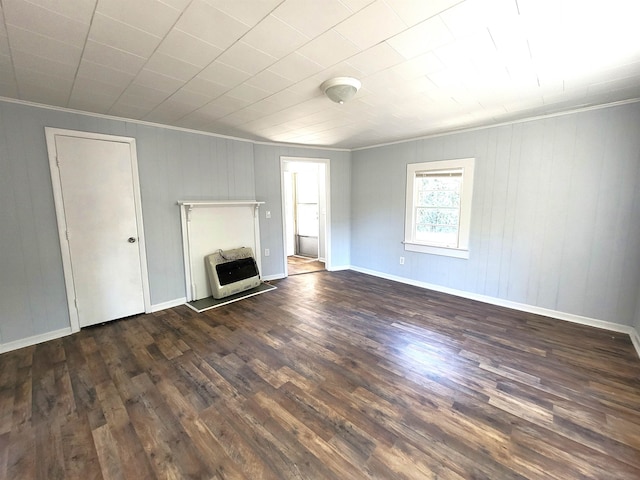 unfurnished living room with heating unit, dark hardwood / wood-style flooring, and ornamental molding