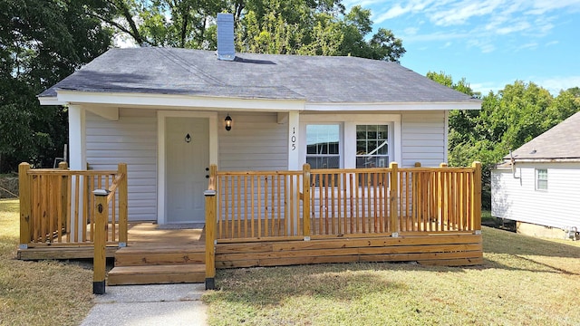 rear view of house with a deck and a yard