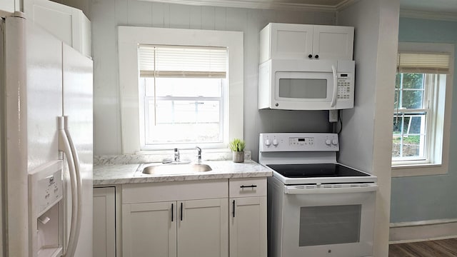 kitchen featuring crown molding, sink, white appliances, and white cabinetry