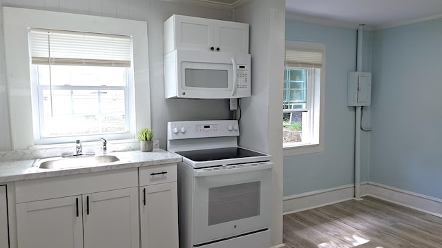 kitchen featuring light wood-type flooring, white cabinetry, white appliances, and sink