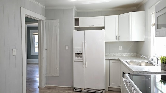 kitchen featuring ornamental molding, sink, wood-type flooring, white cabinetry, and white fridge with ice dispenser