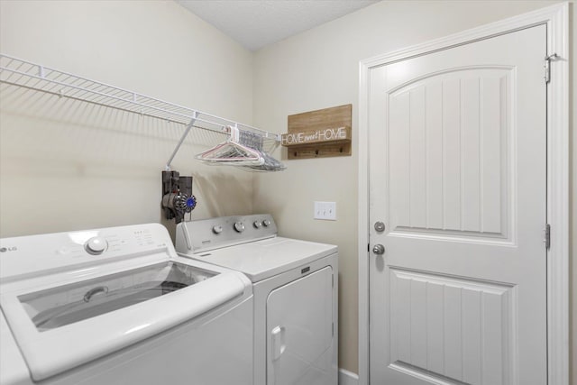 laundry area with separate washer and dryer and a textured ceiling