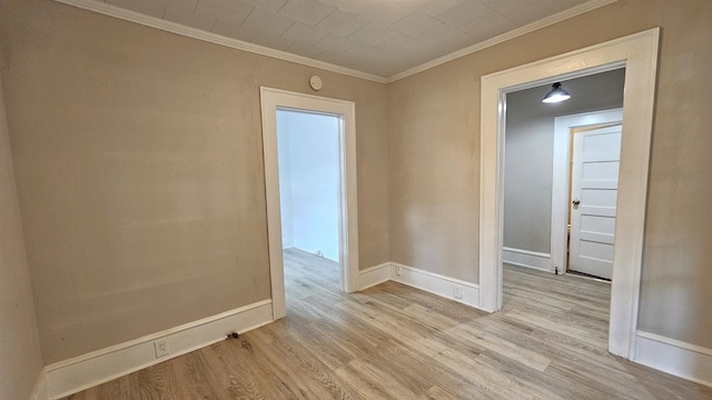 empty room featuring crown molding and light wood-type flooring