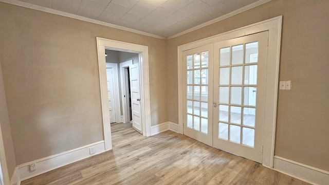 entryway featuring ornamental molding, french doors, and light hardwood / wood-style floors