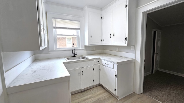 kitchen featuring light wood-type flooring, sink, and white cabinets