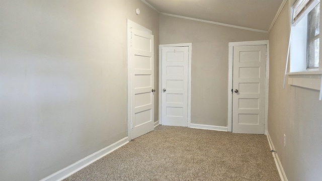 interior space with carpet floors, lofted ceiling, and ornamental molding