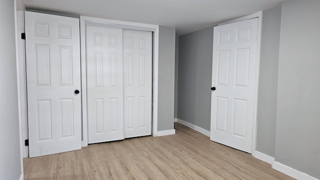 unfurnished bedroom featuring light hardwood / wood-style flooring and a closet