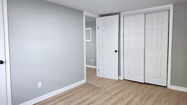 unfurnished bedroom with a closet and light hardwood / wood-style floors