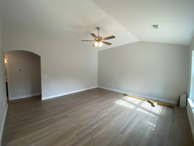 empty room with lofted ceiling, ceiling fan, and dark hardwood / wood-style floors