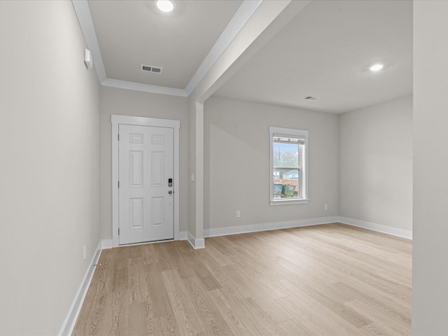 foyer entrance with crown molding and light wood-type flooring