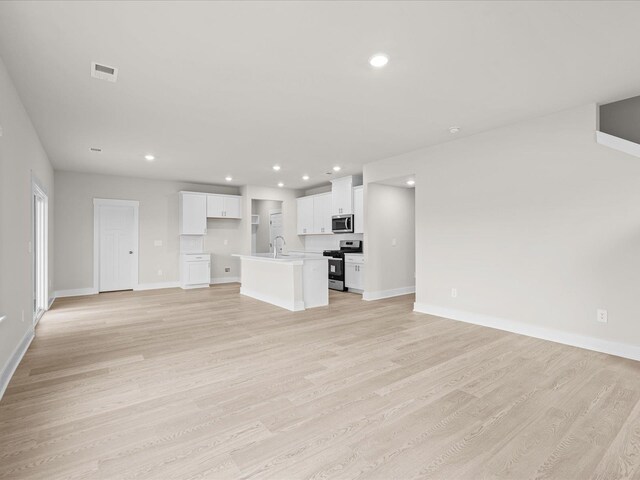 unfurnished living room with light hardwood / wood-style floors and sink