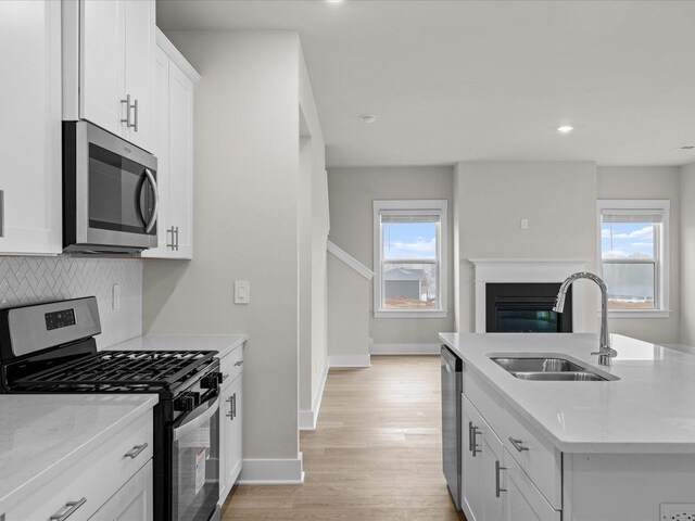 kitchen featuring white cabinets, a healthy amount of sunlight, sink, and appliances with stainless steel finishes