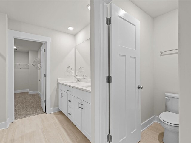 bathroom featuring vanity, hardwood / wood-style flooring, and toilet