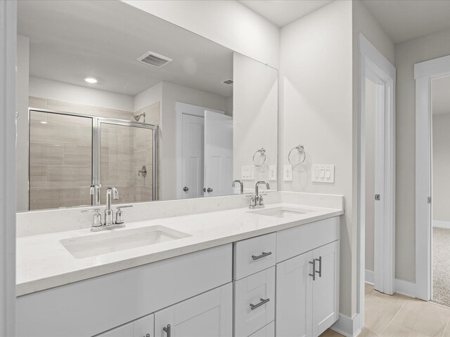 bathroom featuring tile patterned floors, vanity, and a shower with shower door