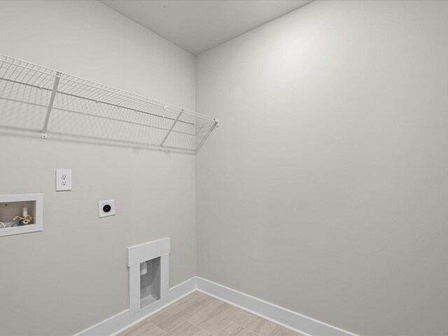 clothes washing area with hookup for a washing machine, light hardwood / wood-style flooring, and electric dryer hookup