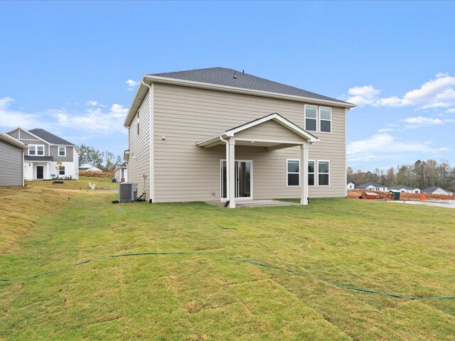 back of property featuring a yard and central AC unit