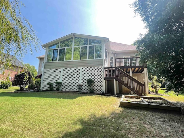 view of side of home featuring a deck, a lawn, and a sunroom