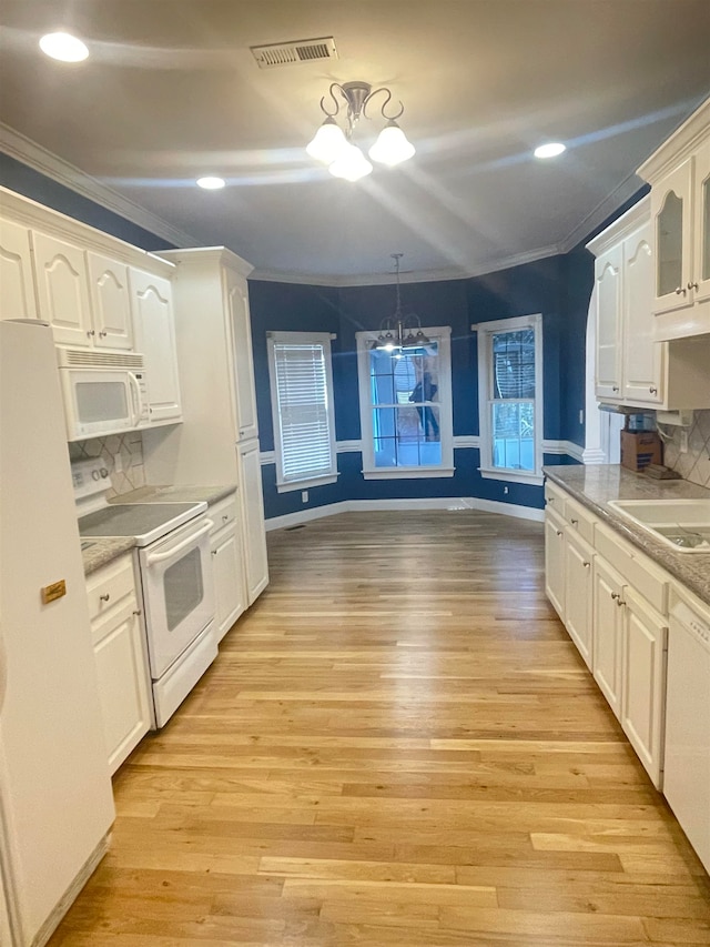 kitchen with white cabinets, light hardwood / wood-style flooring, decorative light fixtures, and white appliances