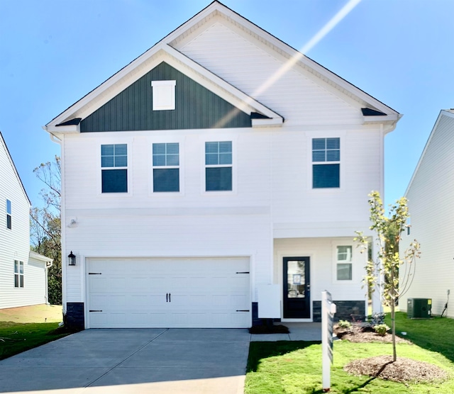 view of front of home featuring central AC unit, a garage, and a front lawn