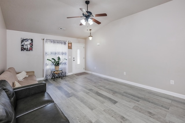 unfurnished living room featuring light hardwood / wood-style flooring, ceiling fan, and vaulted ceiling