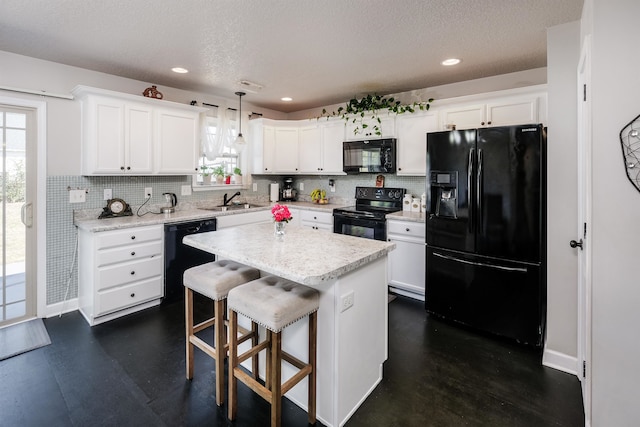 kitchen with a kitchen island, white cabinetry, black appliances, pendant lighting, and sink