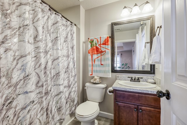 bathroom featuring vanity, toilet, a textured ceiling, and walk in shower