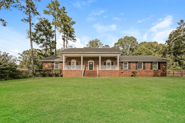 ranch-style house featuring covered porch and a front lawn