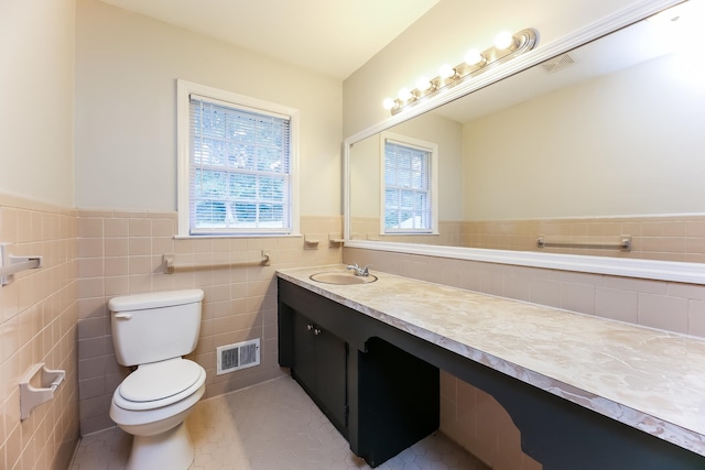 bathroom featuring vanity, tile patterned flooring, toilet, and a wealth of natural light