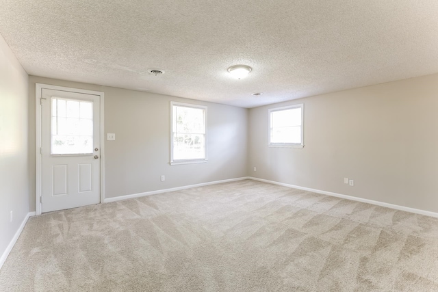 spare room with a textured ceiling and carpet floors