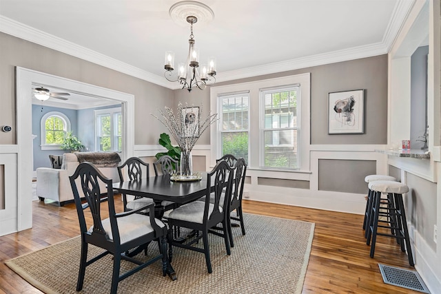 dining room with ornamental molding, hardwood / wood-style flooring, and a wealth of natural light